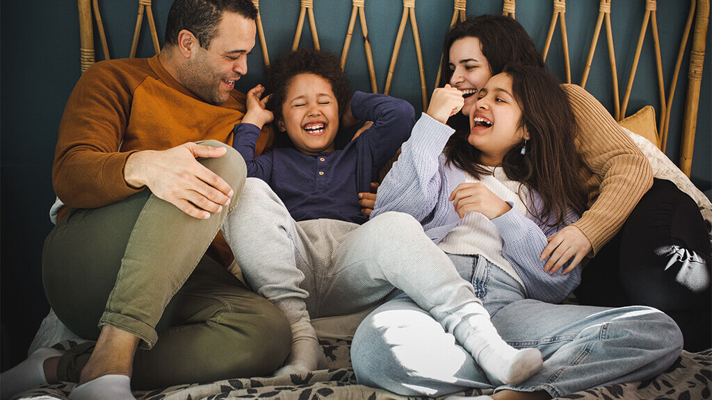 Happy family playing together on a bed