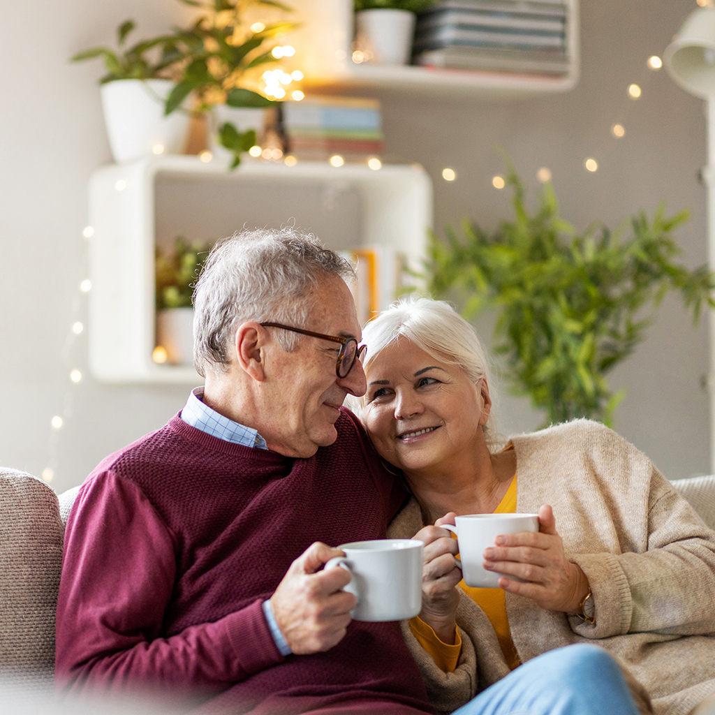 couple on a sofa drinking from mugs couple on a sofa drinking from mugs