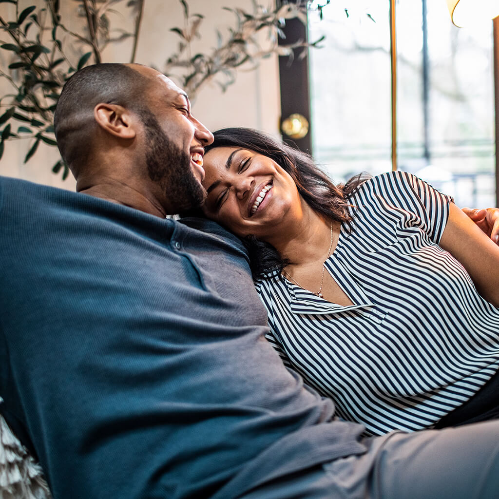  couple on a sofa laughing