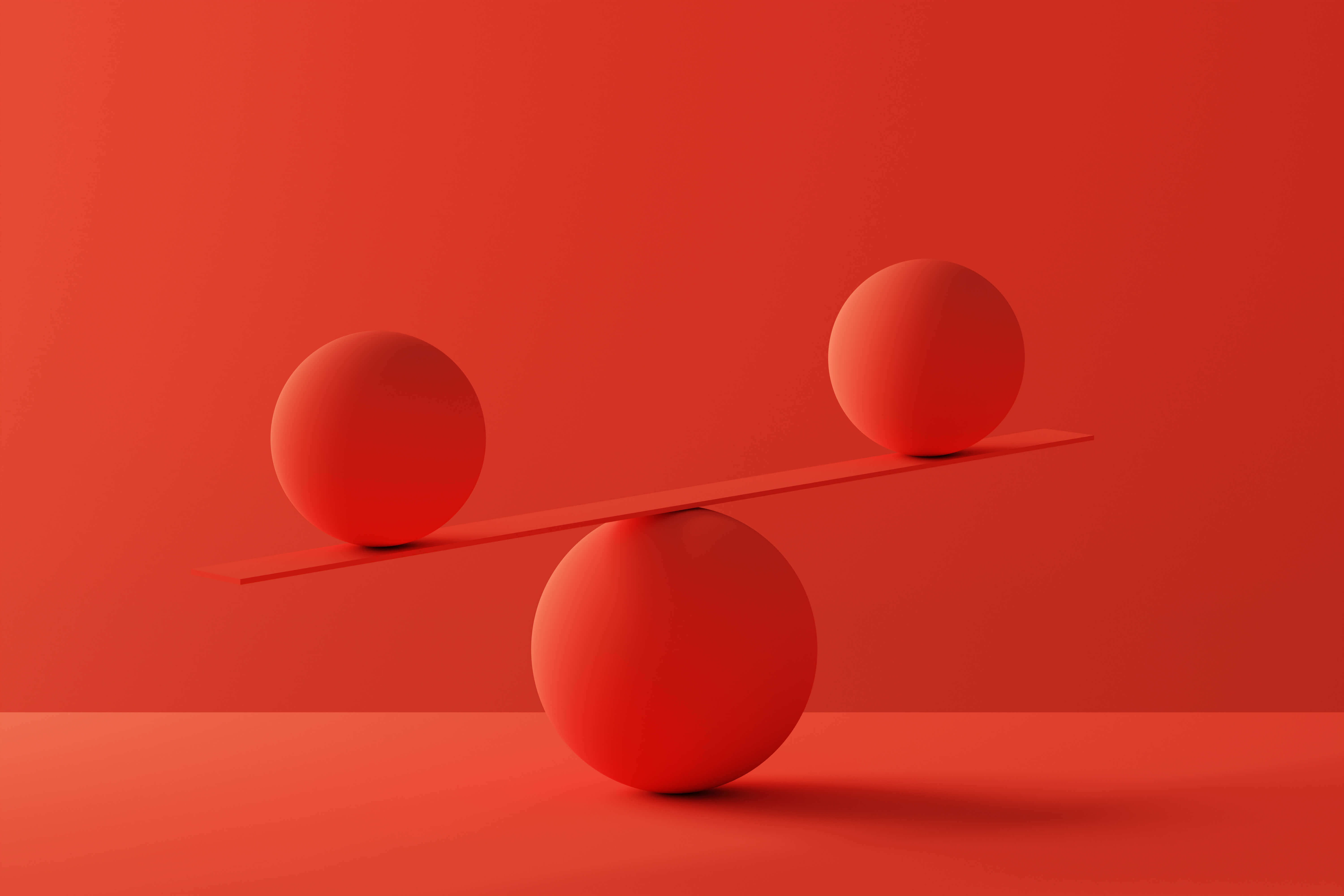 Two spheres in perfect balance over red background Two spheres in perfect balance over red background