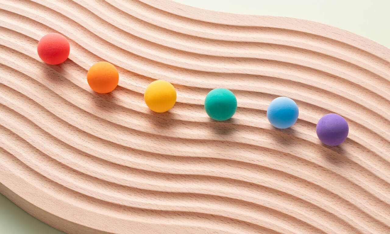 Colourful spheres moving down on s shape wood Colourful spheres moving down on s shape wood