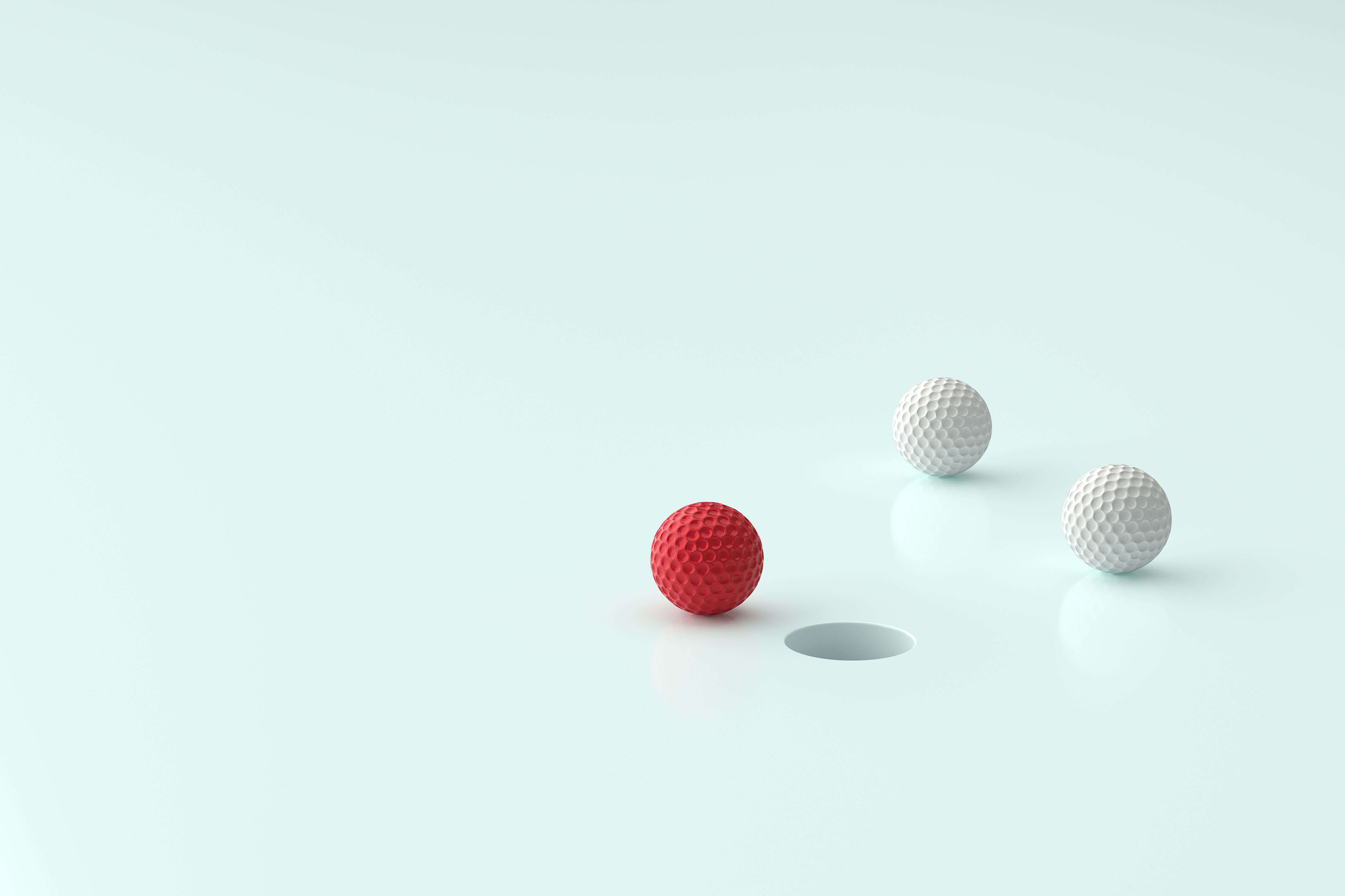 Three golf balls near the hole one of them is red color on light green background Three golf balls near the hole one of them is red color on light green background