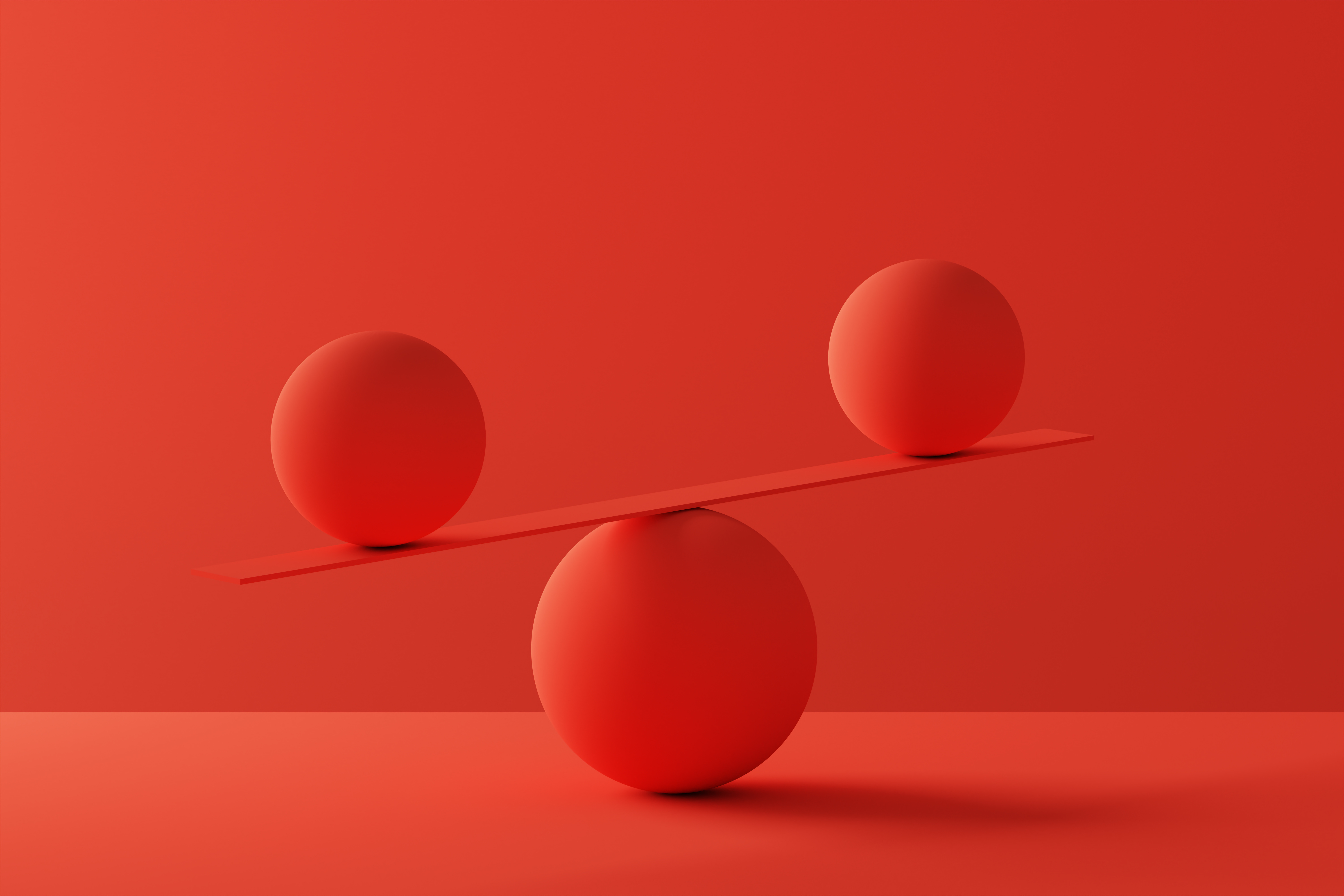 Two spheres in perfect balance over red background