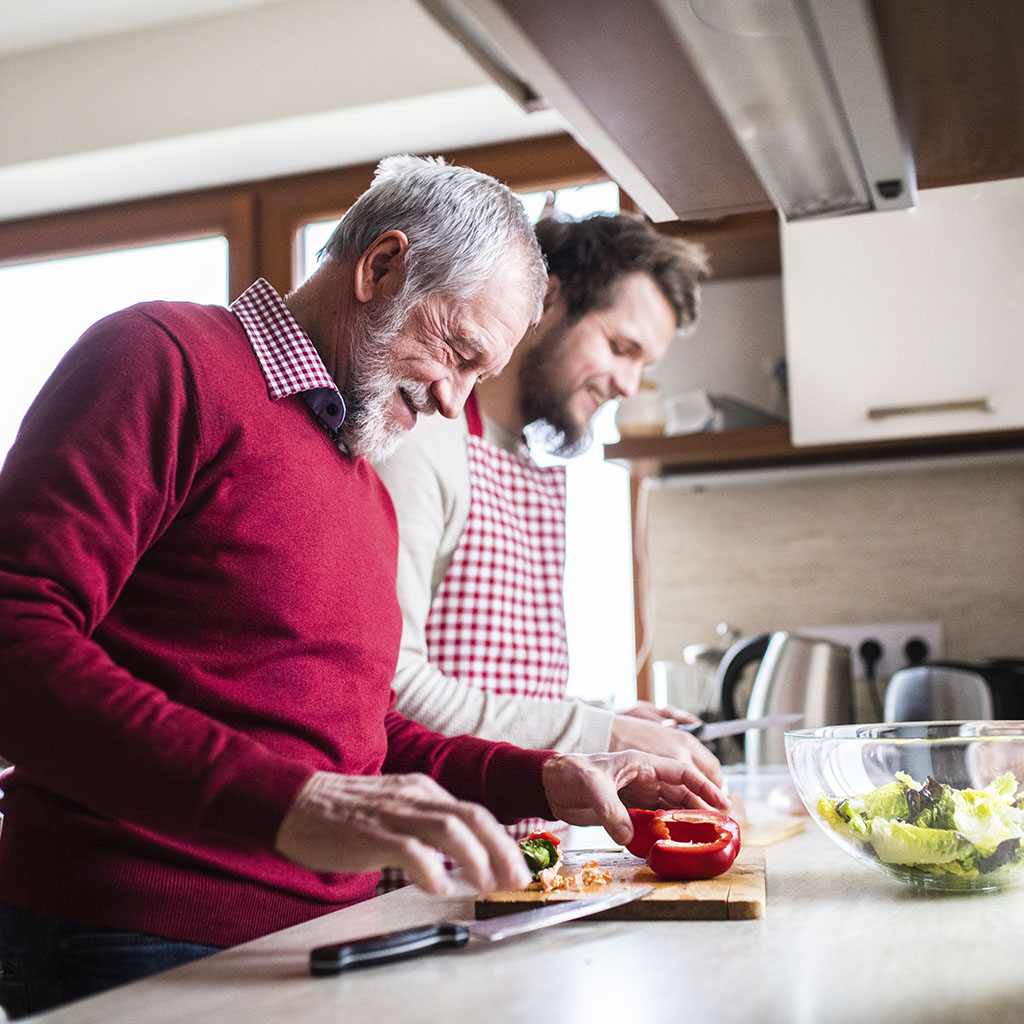 Happy father and son cooking together in a kitchen Happy father and son cooking together in a kitchen